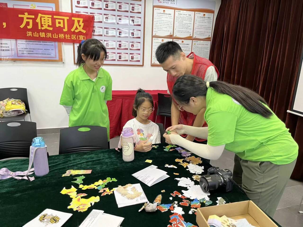 社区儿童手工制作动物模型 实践队队员与社区志愿者协助孩子制作动物手工 刘田川 摄.jpg